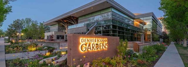 Denver Botanic Gardens sign lit up with lights in front of a two-story building.